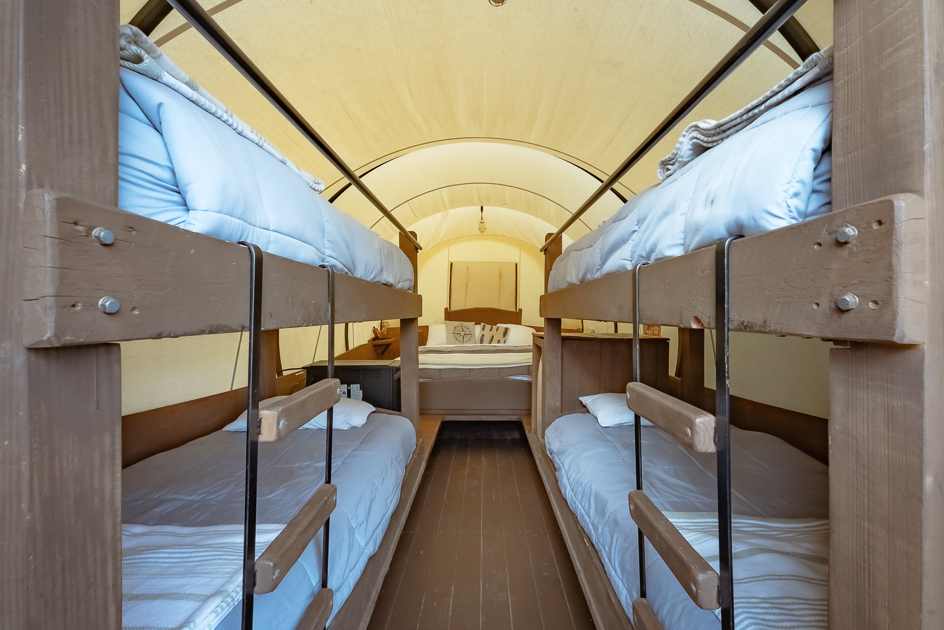 Inside view of a cozy sleeping area with bunk beds in a tent-like structure.