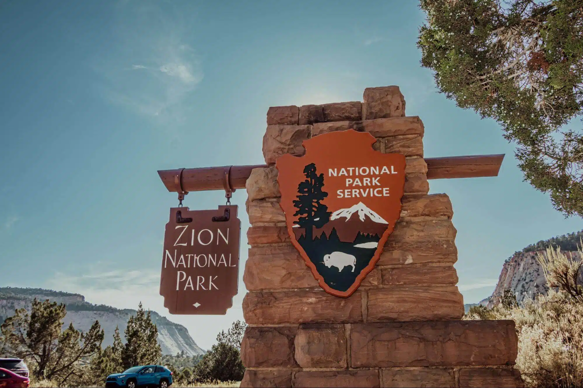 Sign marking the entrance to Zion National Park with the National Park Service emblem.
