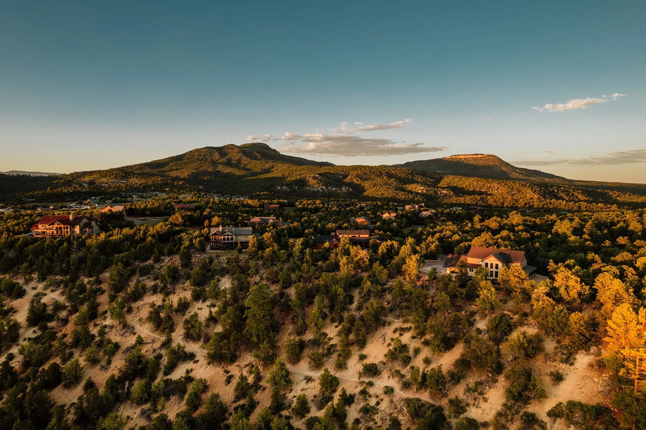 Aerial view of rolling hills and residential areas at sunset.