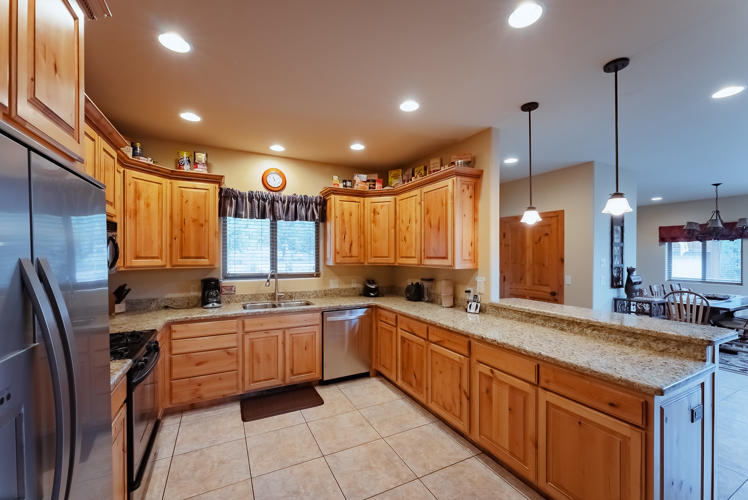 A spacious kitchen featuring wooden cabinets, granite countertops, and modern appliances.