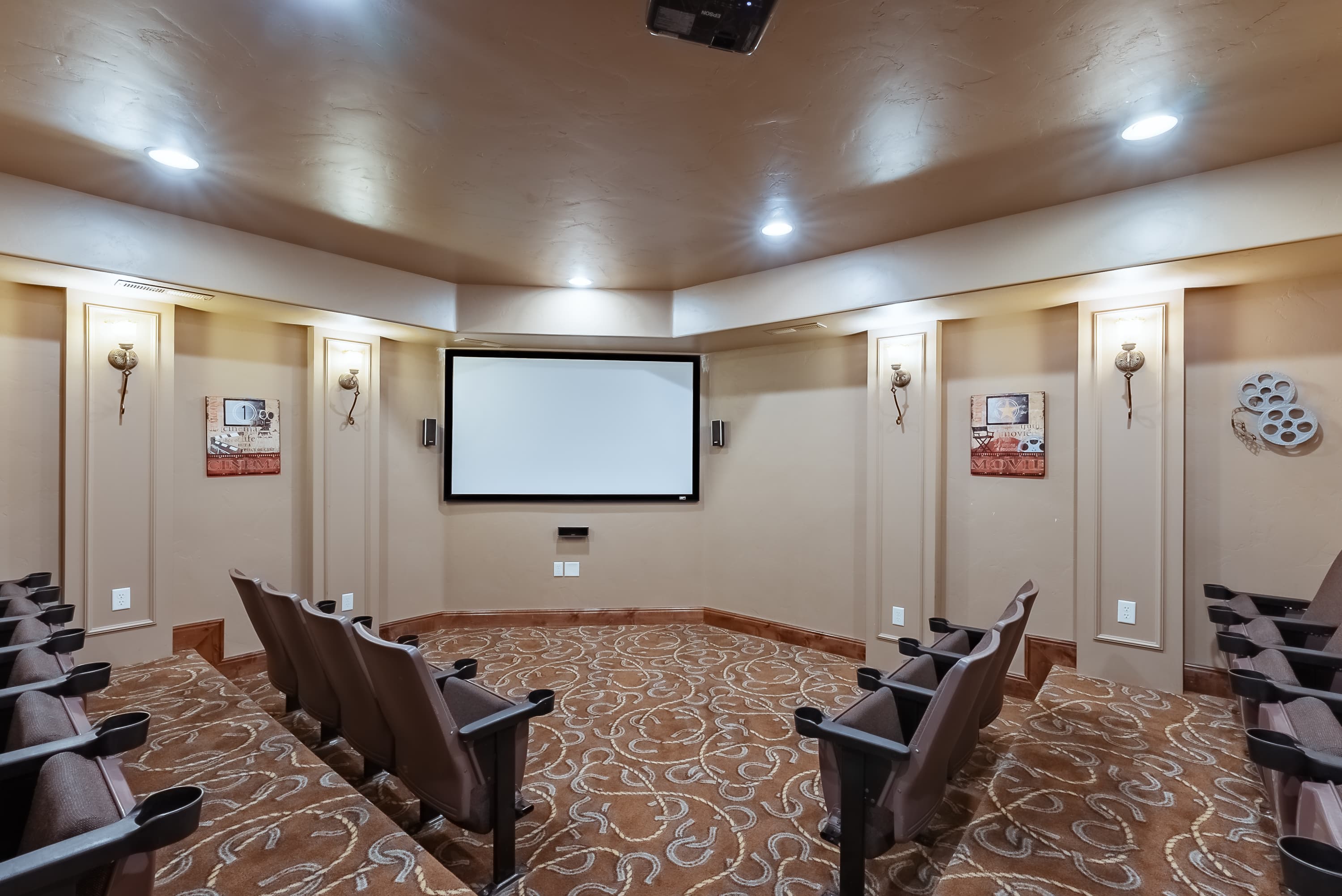 Home theater with seating arranged around a central screen and decorative wall accents.