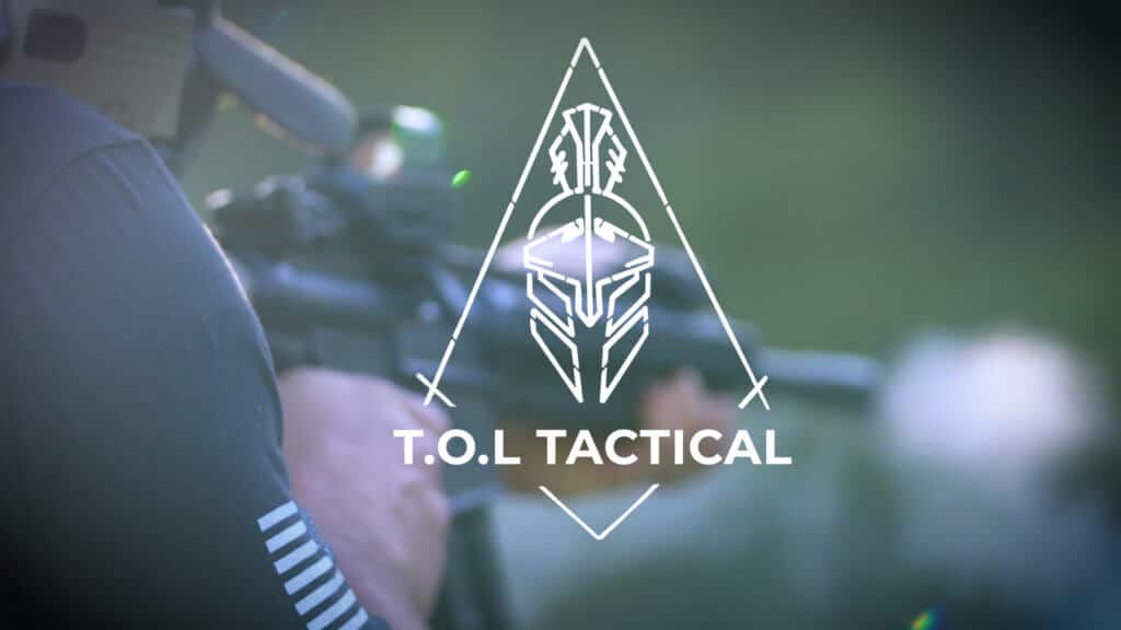 A close-up of a person aiming a rifle, with the logo for "T.O.L Tactical" prominently displayed.