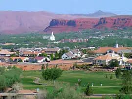 A panoramic view of a residential area surrounded by mountains and greenery.