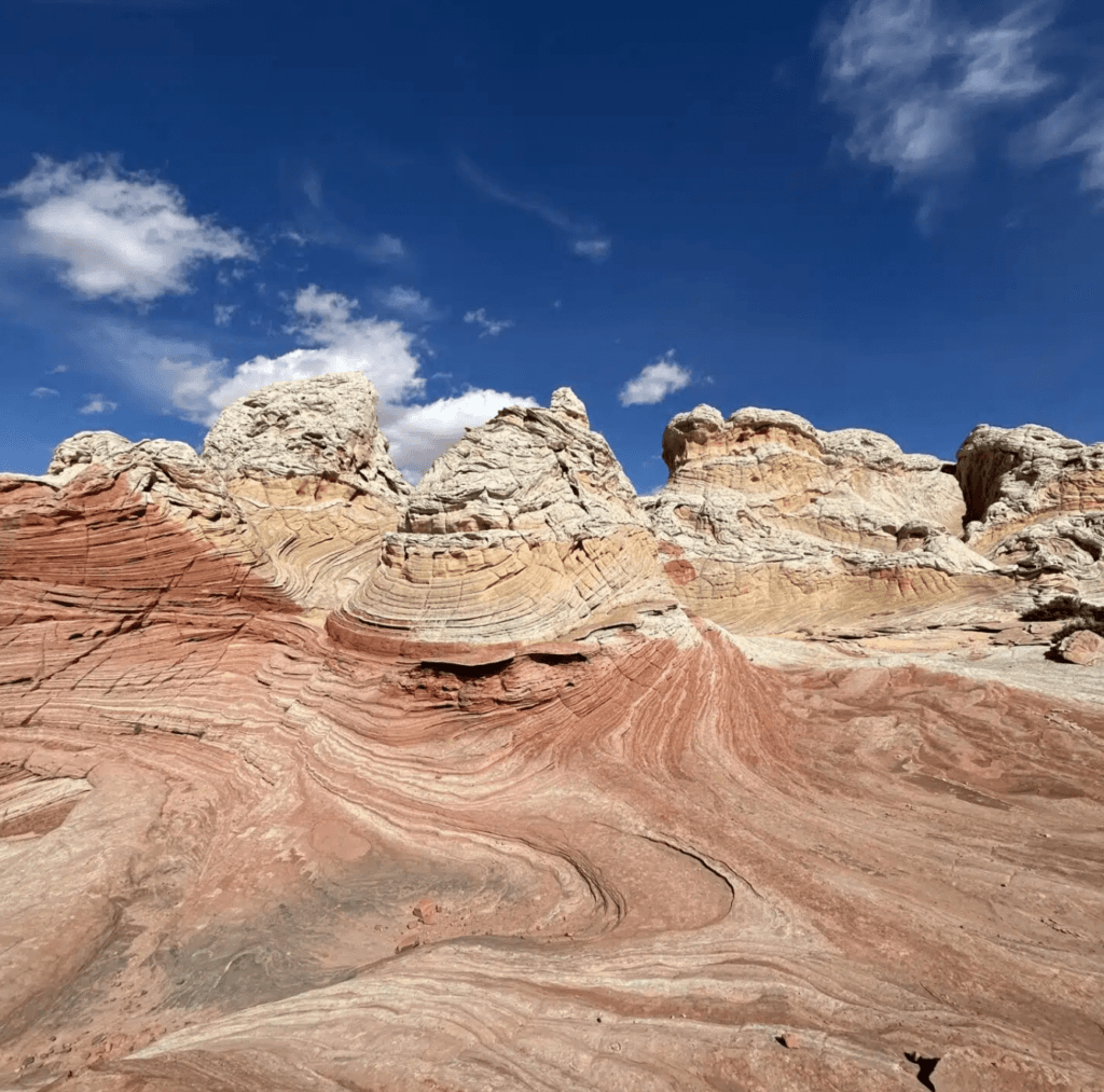 Layered rock formations with colorful stripes under a clear blue sky.