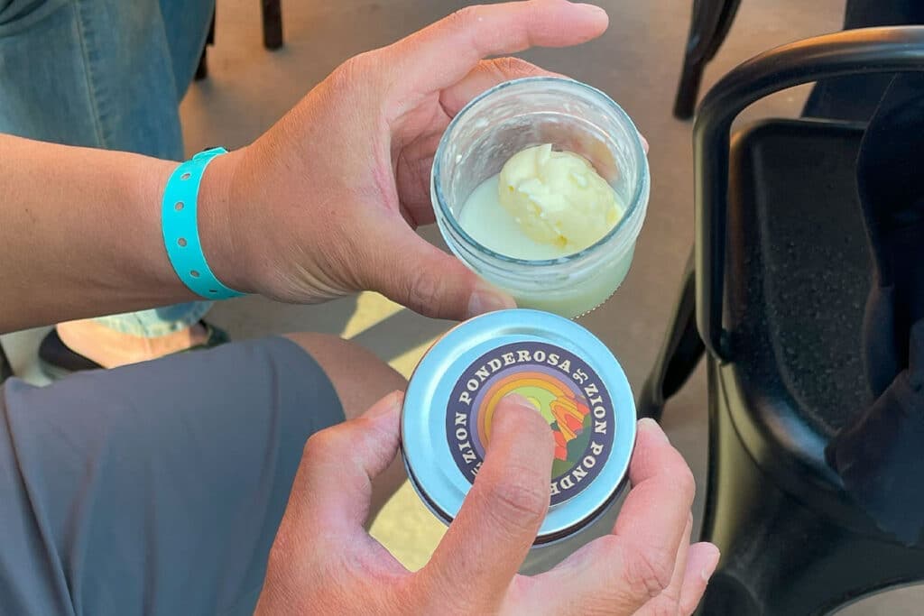 A person holds a jar with a creamy substance and a lid labeled "Ponderosa."