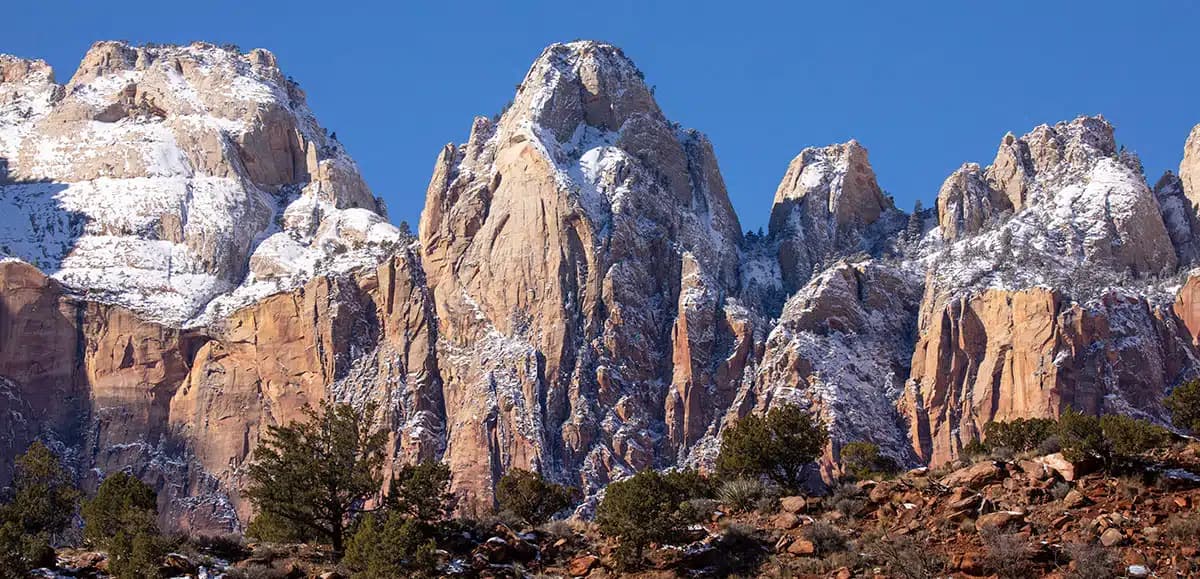 Snow-capped rocky mountains under a clear blue sky.