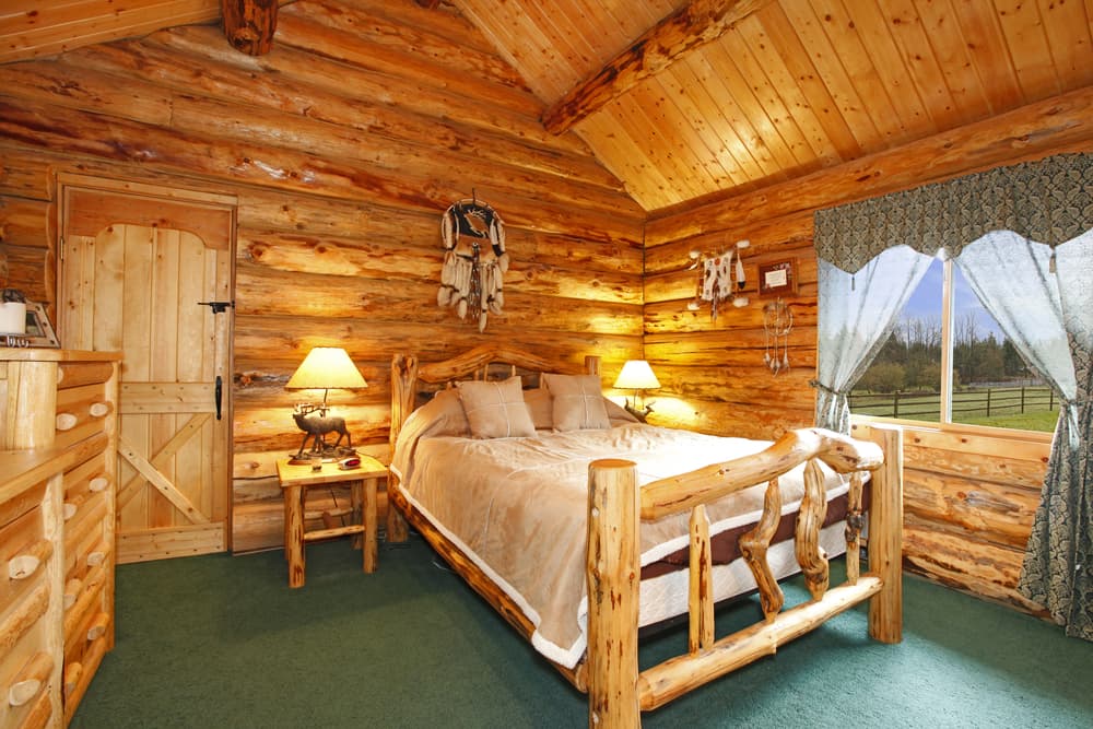 Cozy log cabin bedroom with wooden furnishings and soft lighting.