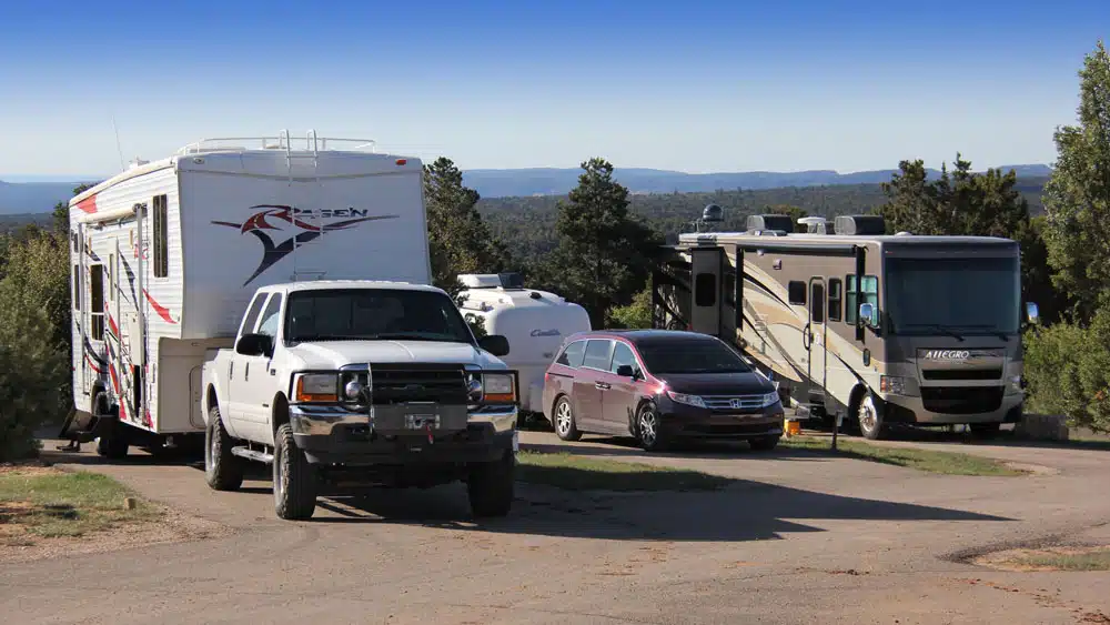 and RV and 2 camper trailers are parked in a campground with scenic views near Zion National Park