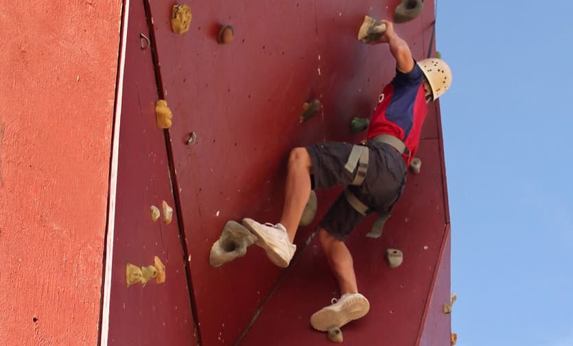 A climber ascends a vertical rock wall.