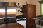 A kitchen featuring a stainless steel refrigerator, gas stove, and wooden cabinetry.