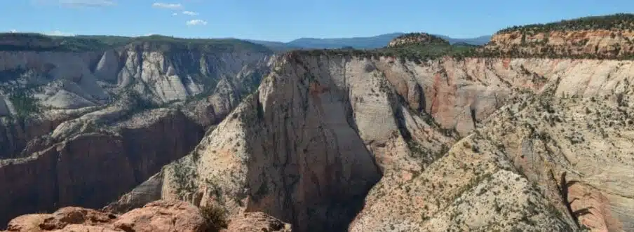 A sweeping view of a rugged canyon landscape under a clear blue sky.