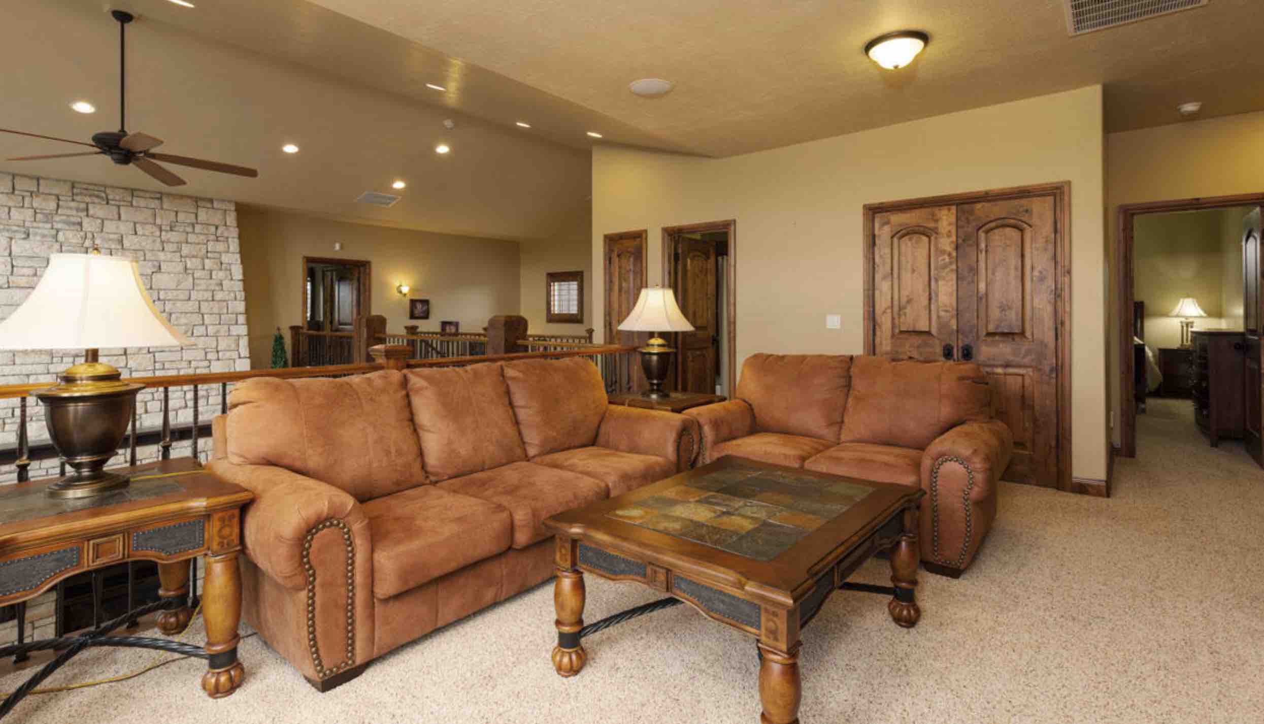 A cozy living room featuring brown sofas, a wooden coffee table, and a warm color palette.