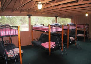 A cozy cabin interior featuring multiple bunk beds and seating areas.