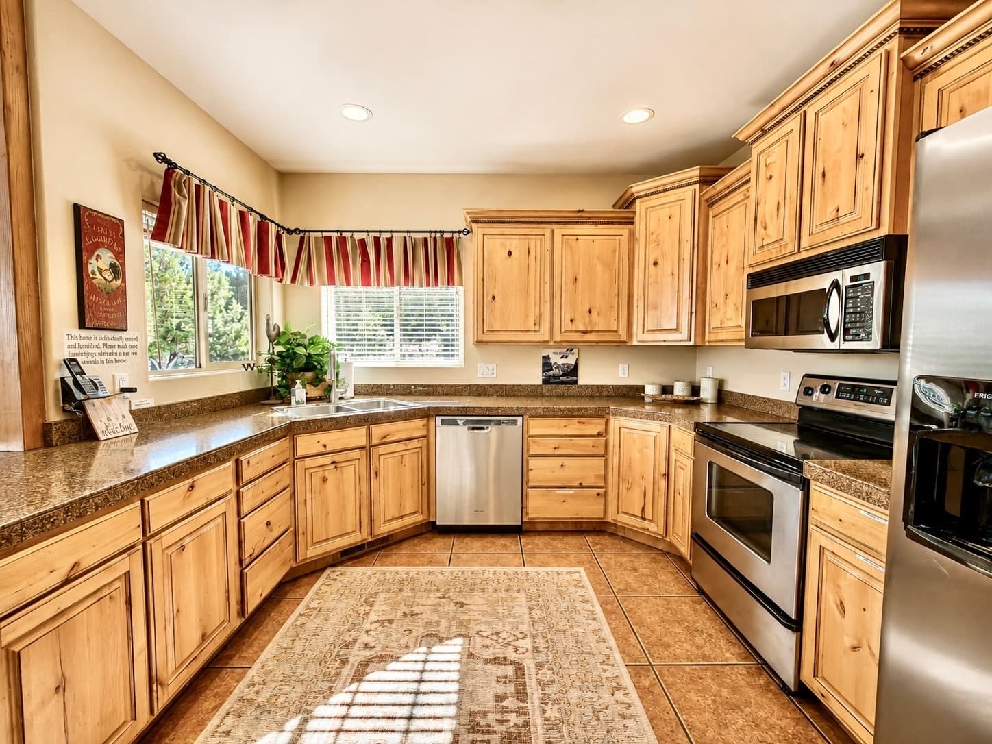 Modern kitchen with wooden cabinets, stainless steel appliances, and a cozy rug.