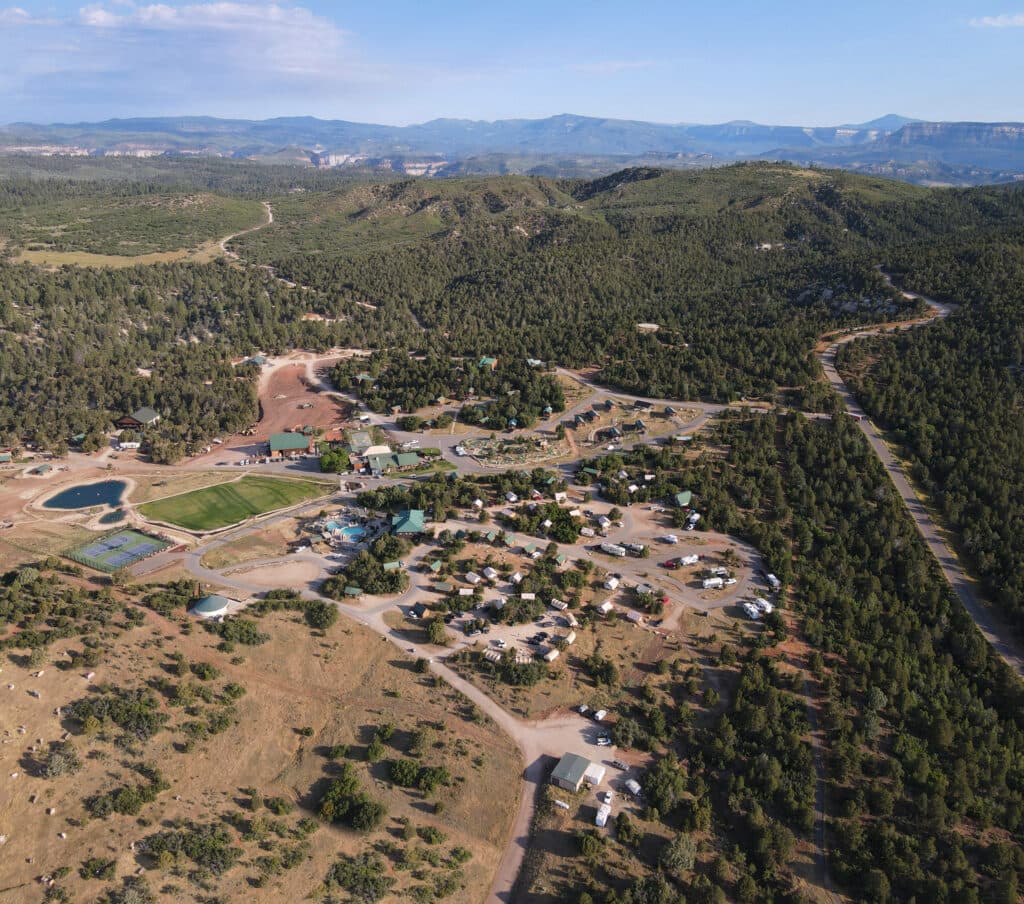 Aerial view of a rural community surrounded by mountains and greenery.