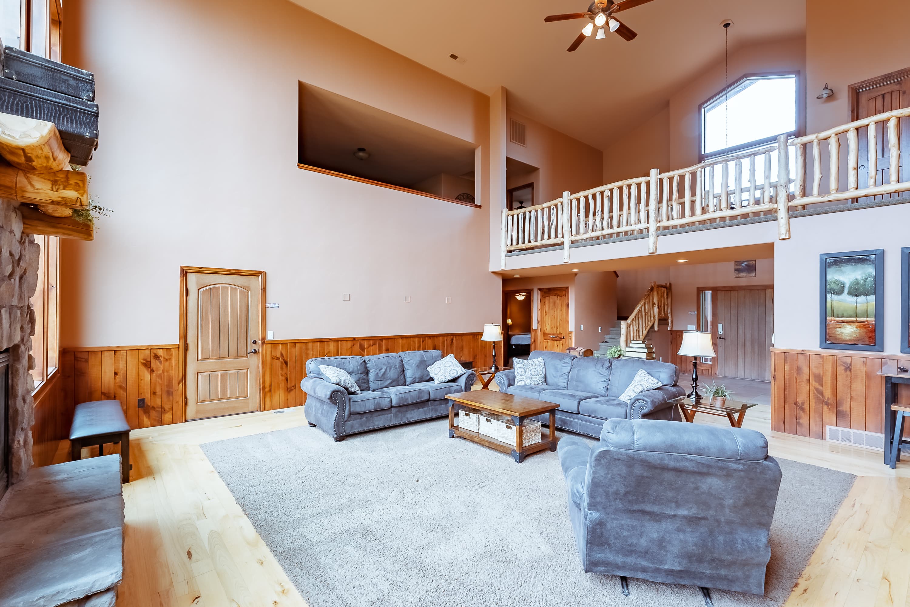 Spacious living room with high ceilings, wooden accents, and comfortable seating.