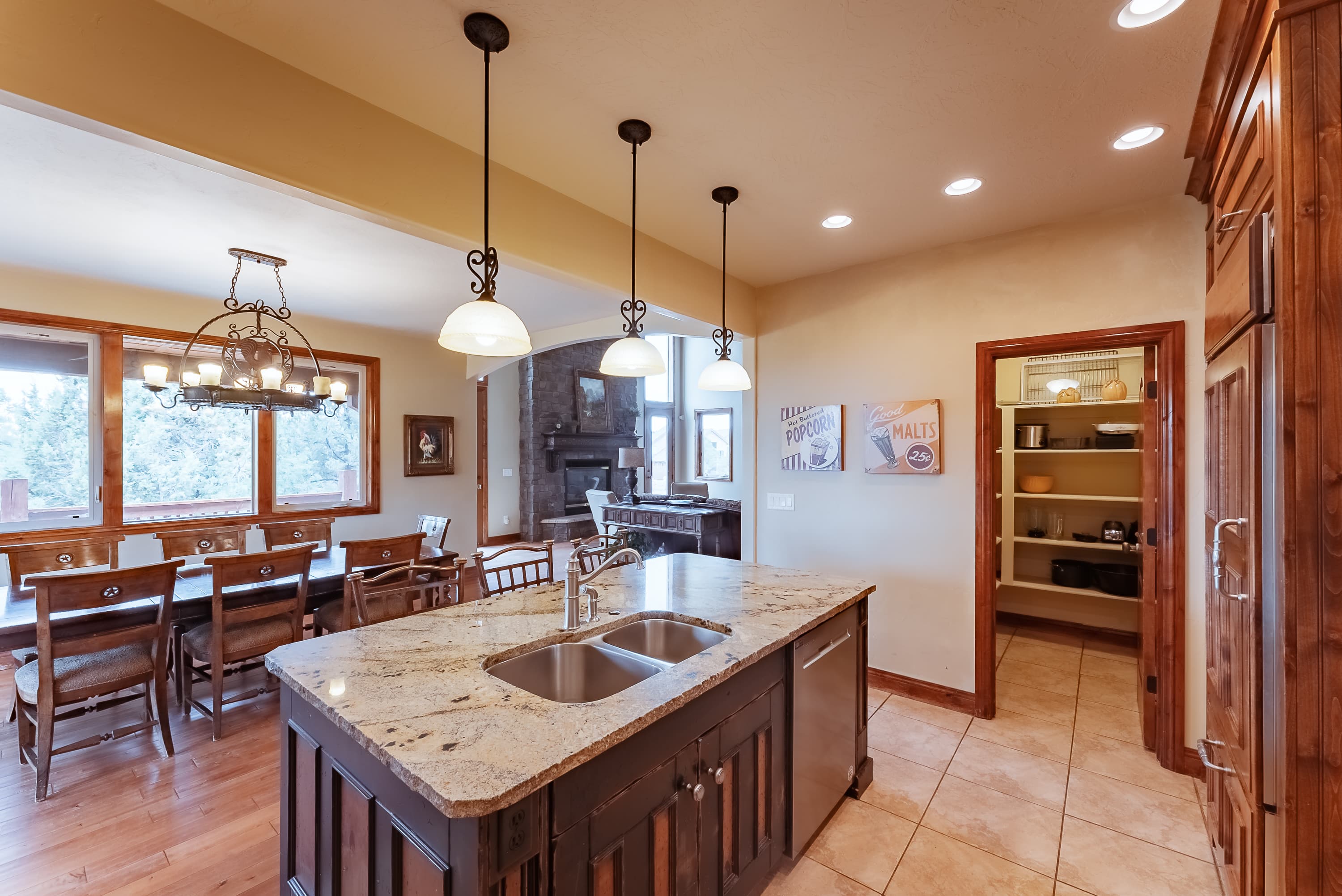 Modern kitchen featuring a central island, pendant lighting, and an adjacent dining area.