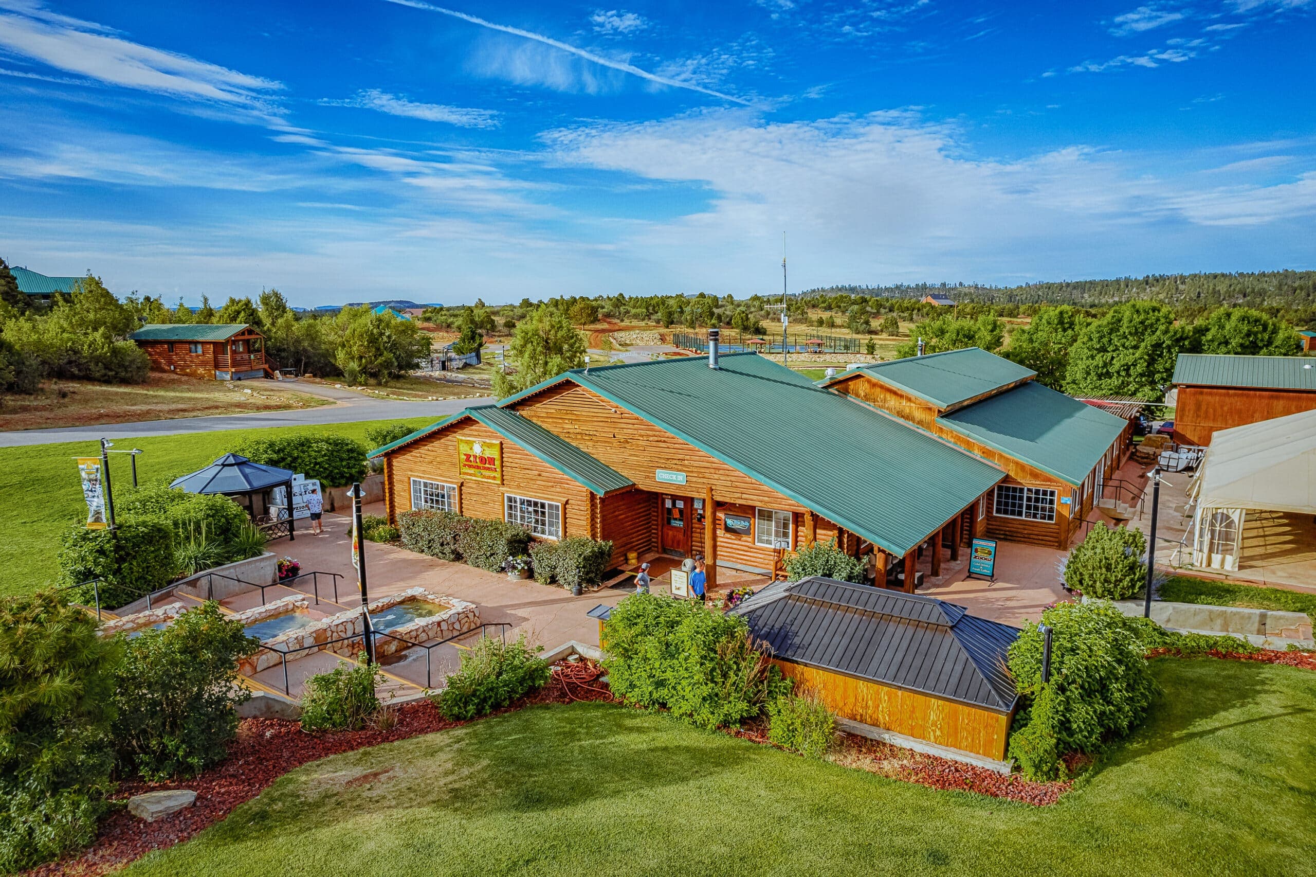 A picturesque wooden building with green roofs surrounded by landscaped gardens.