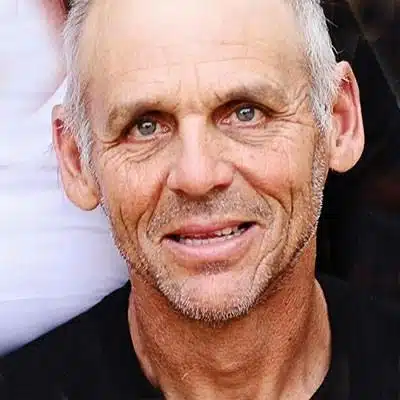 A middle-aged man with short gray hair and a slight beard smiles at the camera.