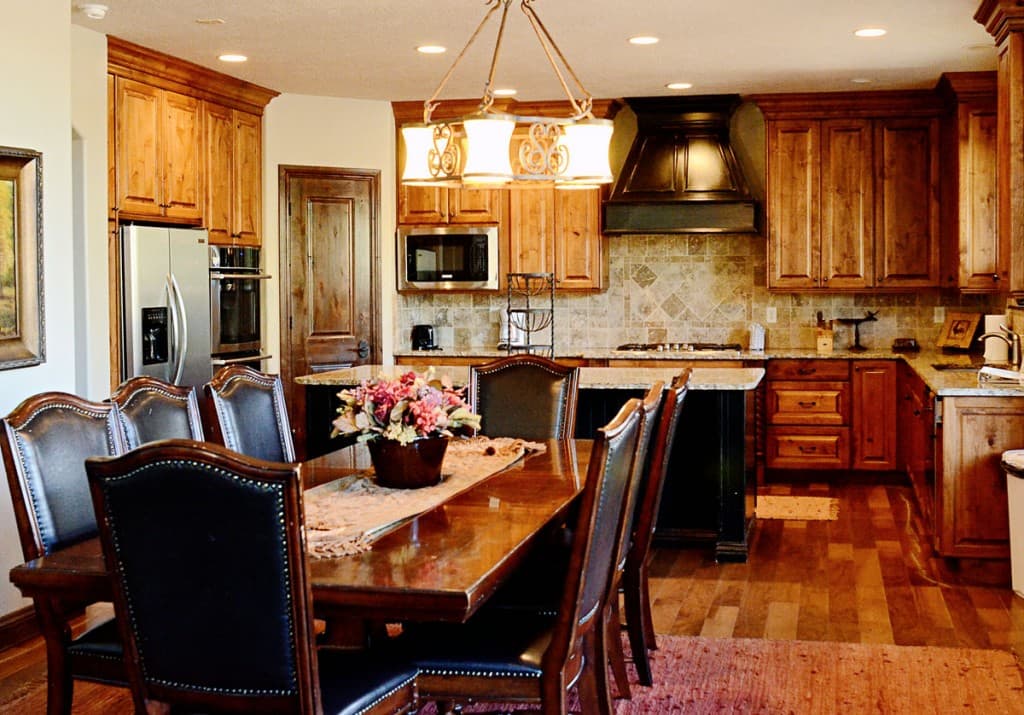 A cozy kitchen with wooden cabinets, a dining table, and modern appliances.