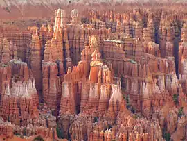 Colorful rock formations rise sharply from the ground in a rugged landscape.