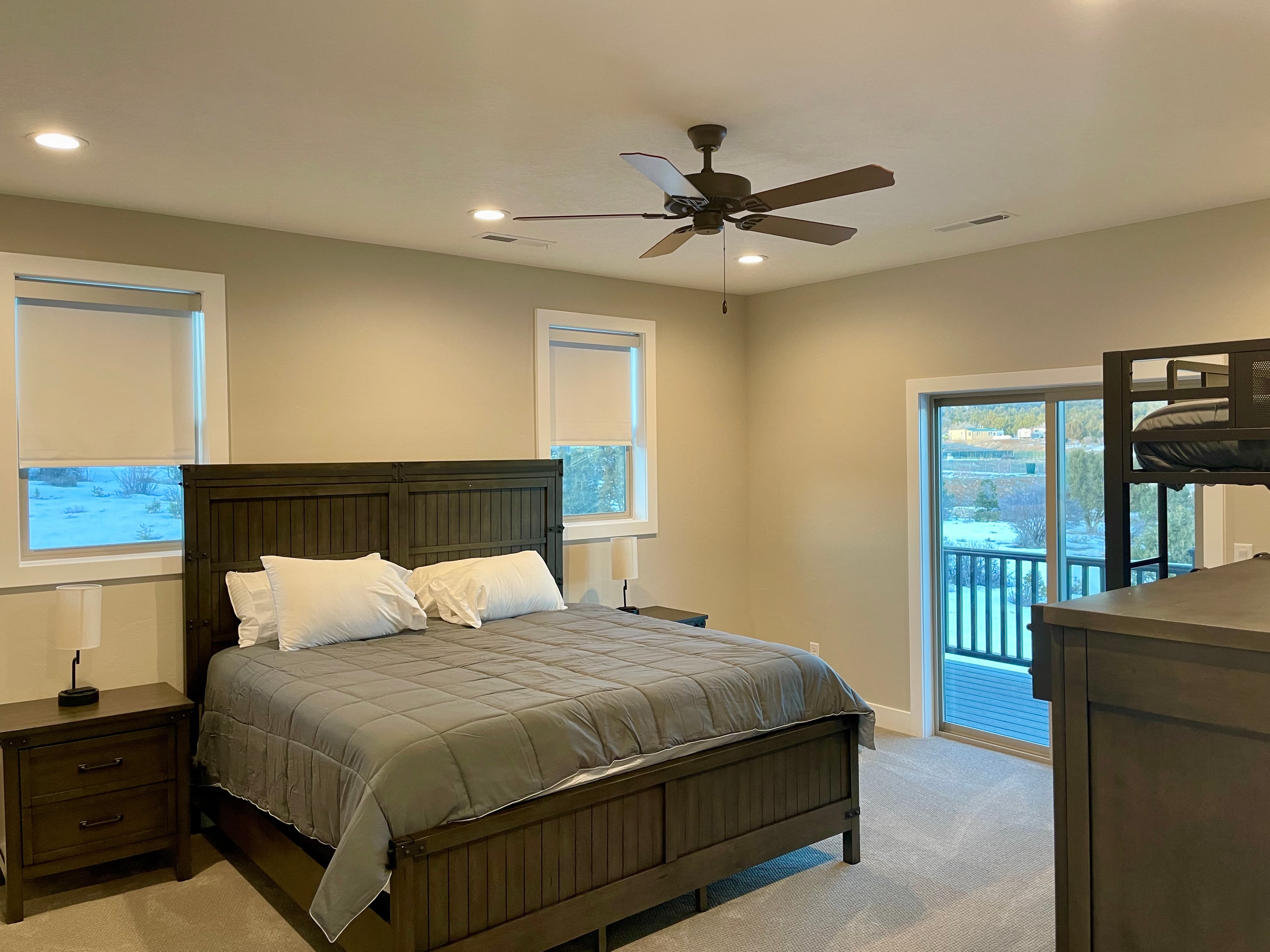 A modern bedroom featuring a large bed, nightstands, and a balcony door.