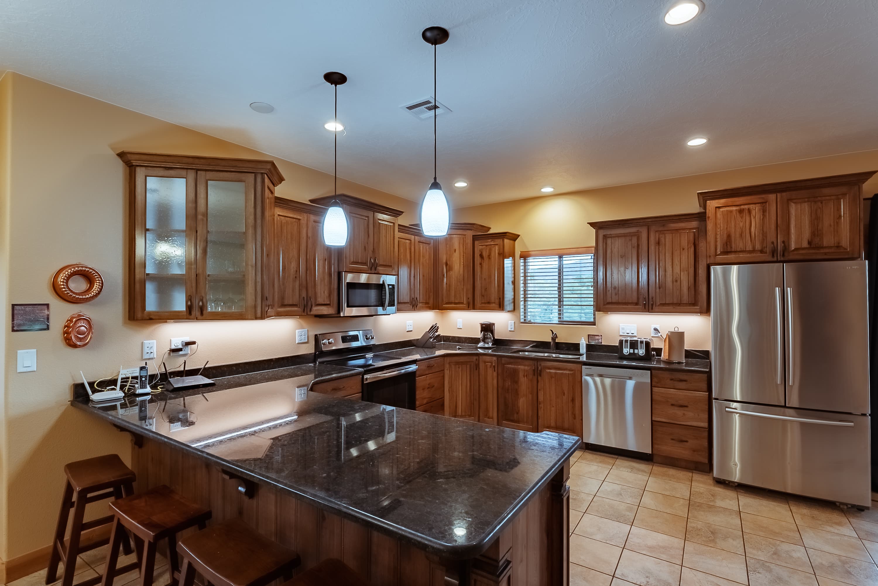 Modern kitchen featuring wooden cabinetry, a large island, and stainless steel appliances.