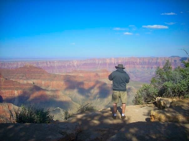 A person stands at the edge of the Grand Canyon, gazing out at the expansive view.