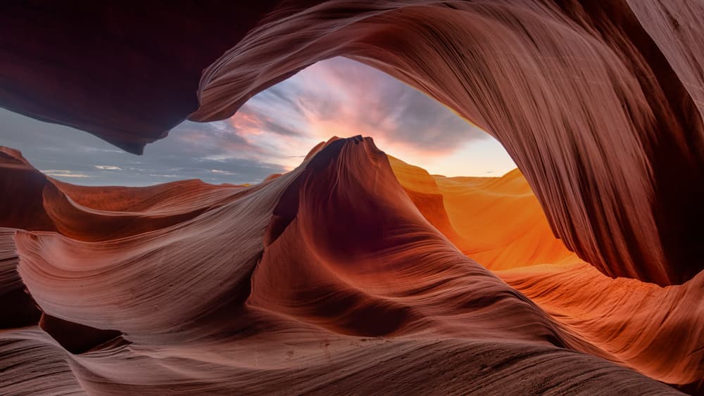 A stunning view of winding sandstone formations illuminated by a sunset sky.