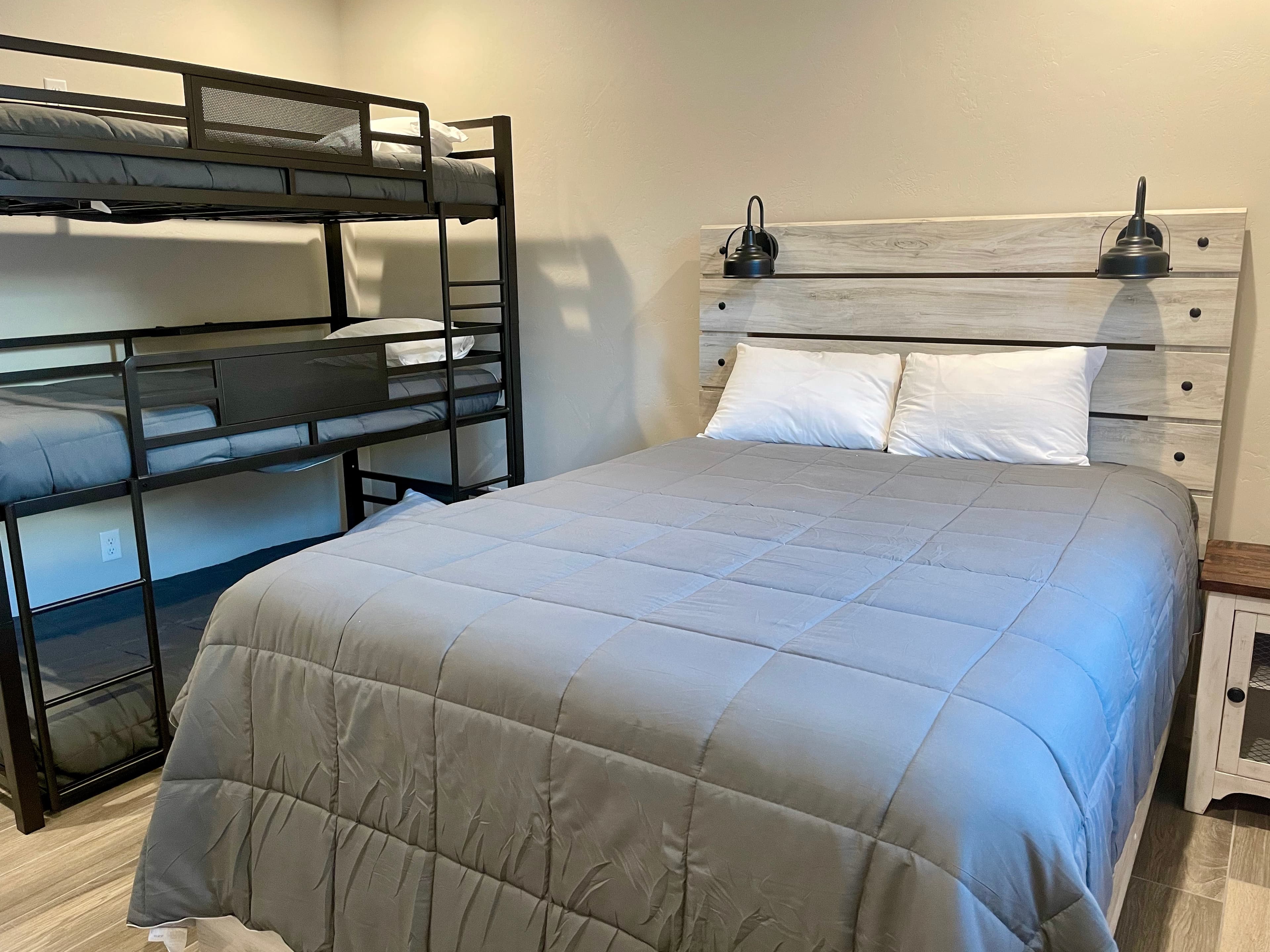 Cozy bedroom featuring a queen bed and a black metal bunk bed.