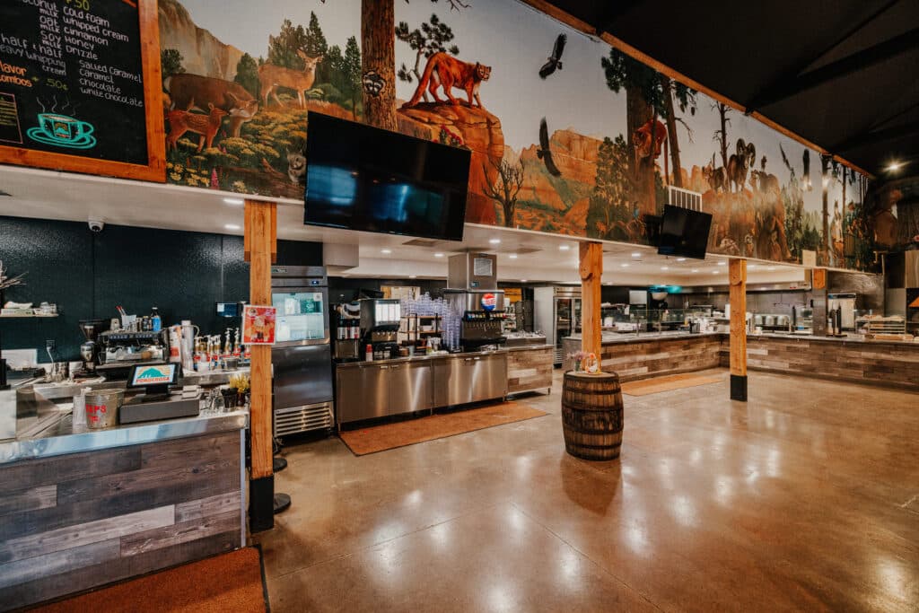 Interior of a café featuring a scenic mural and modern furnishings.