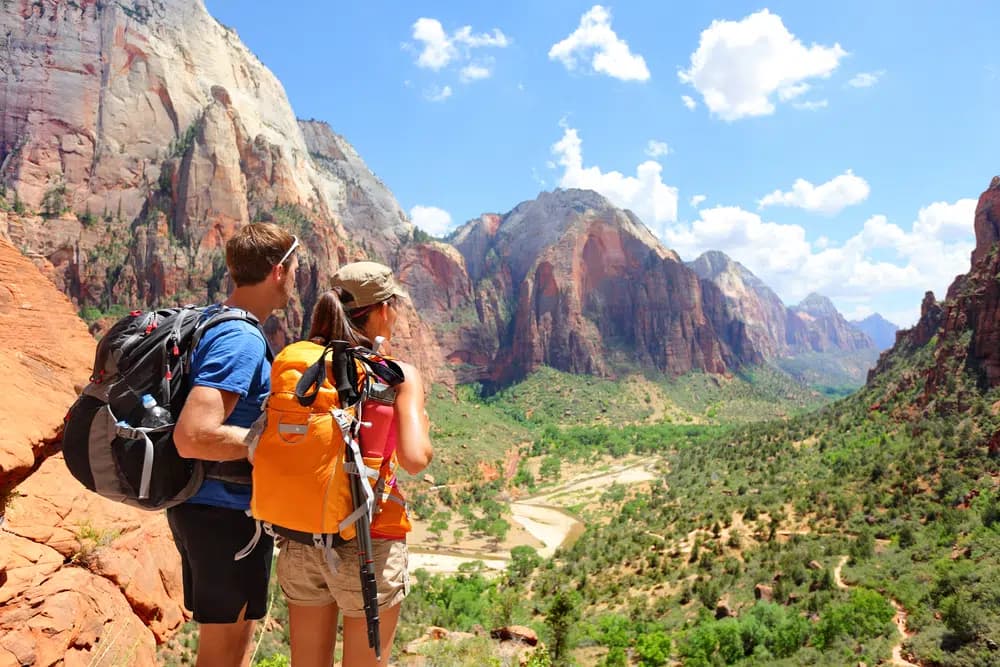 Two hikers admire a scenic view of Zion National Park.
