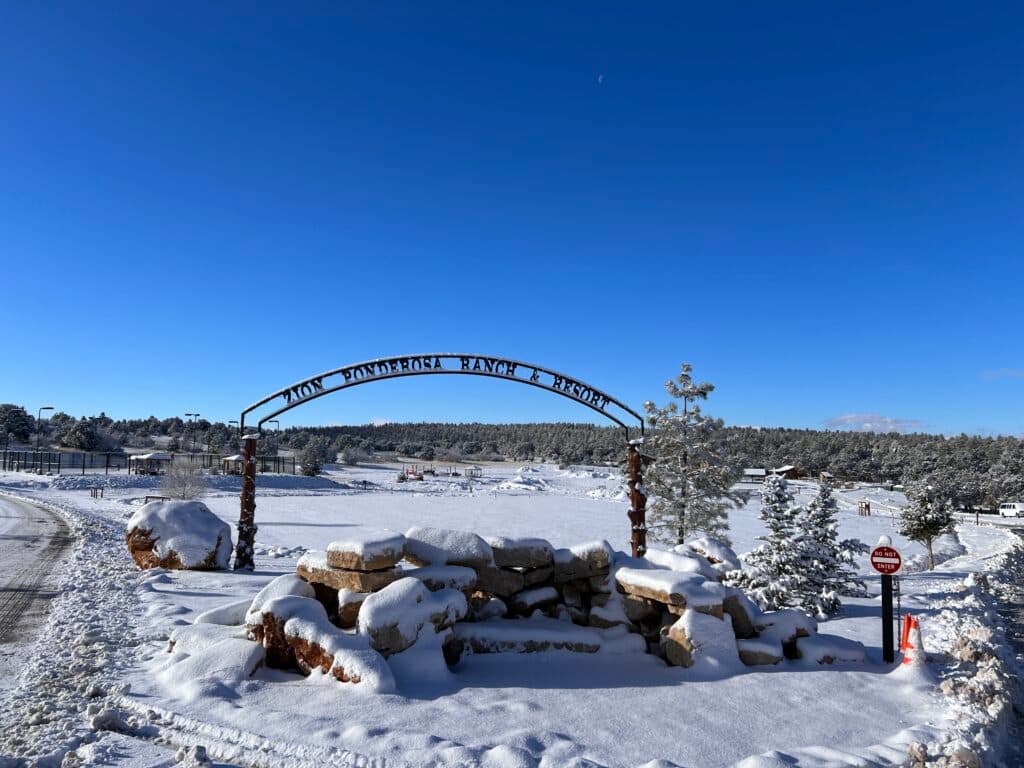 A snow-covered ranch entrance under a clear blue sky.