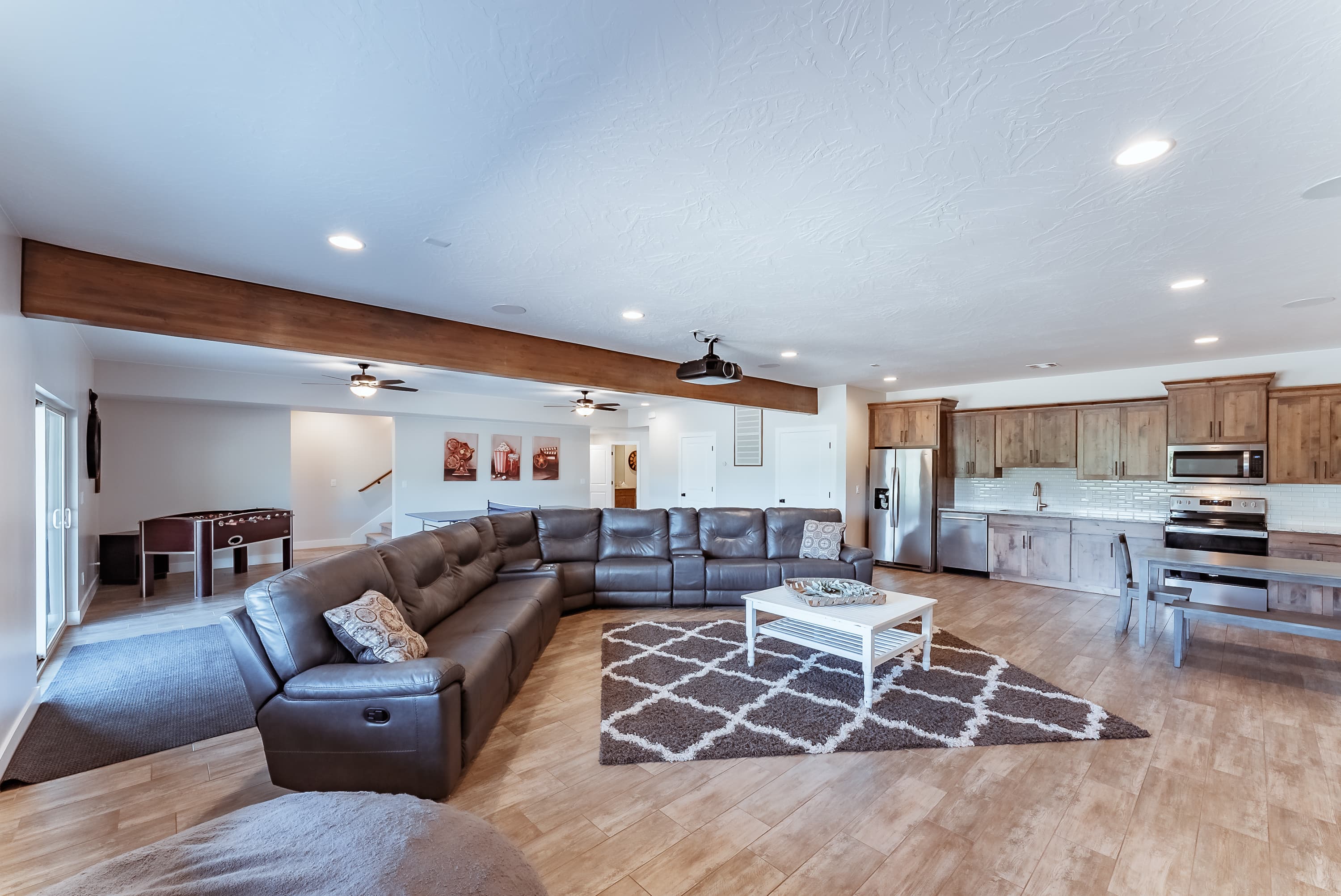 Cozy living room featuring a large sectional sofa, coffee table, and adjacent kitchen.