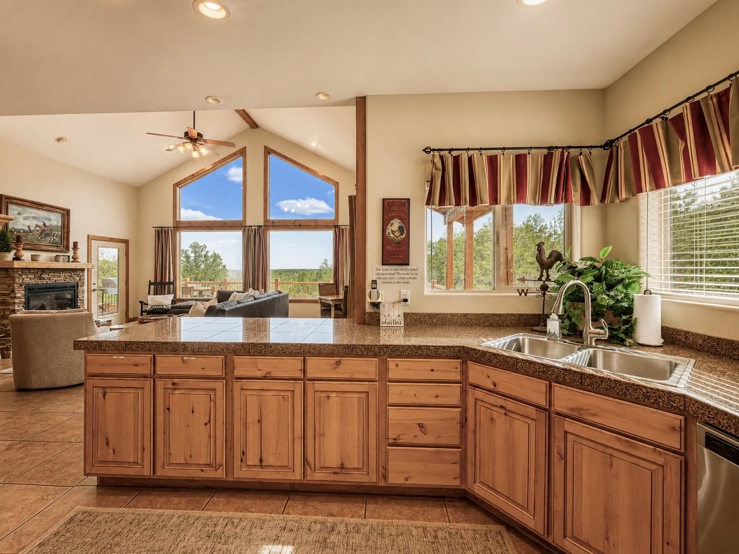 Bright kitchen featuring wooden cabinets, a countertop, and large windows with scenic views.