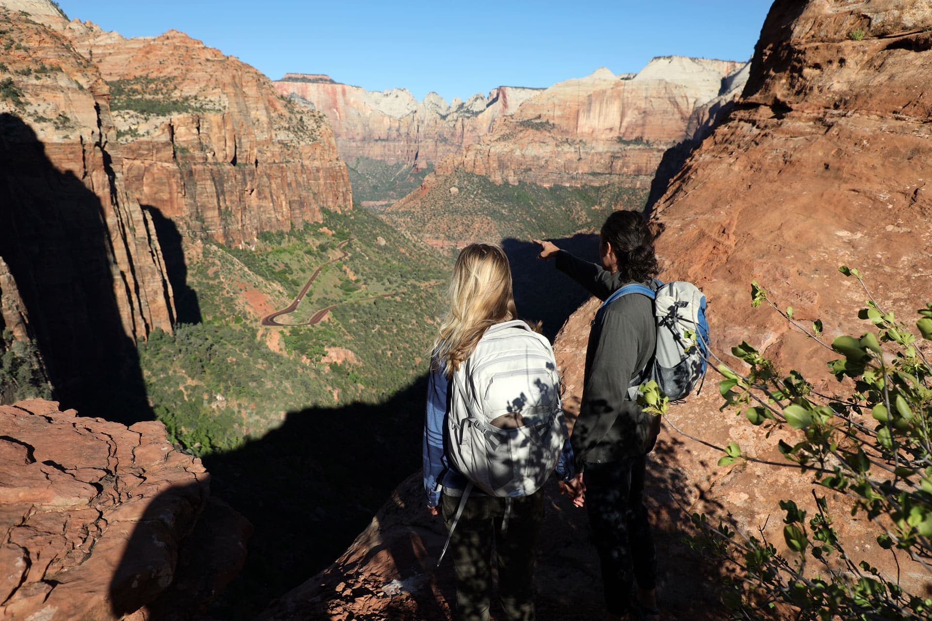 Two hikers gazing out over a vast canyon landscape.