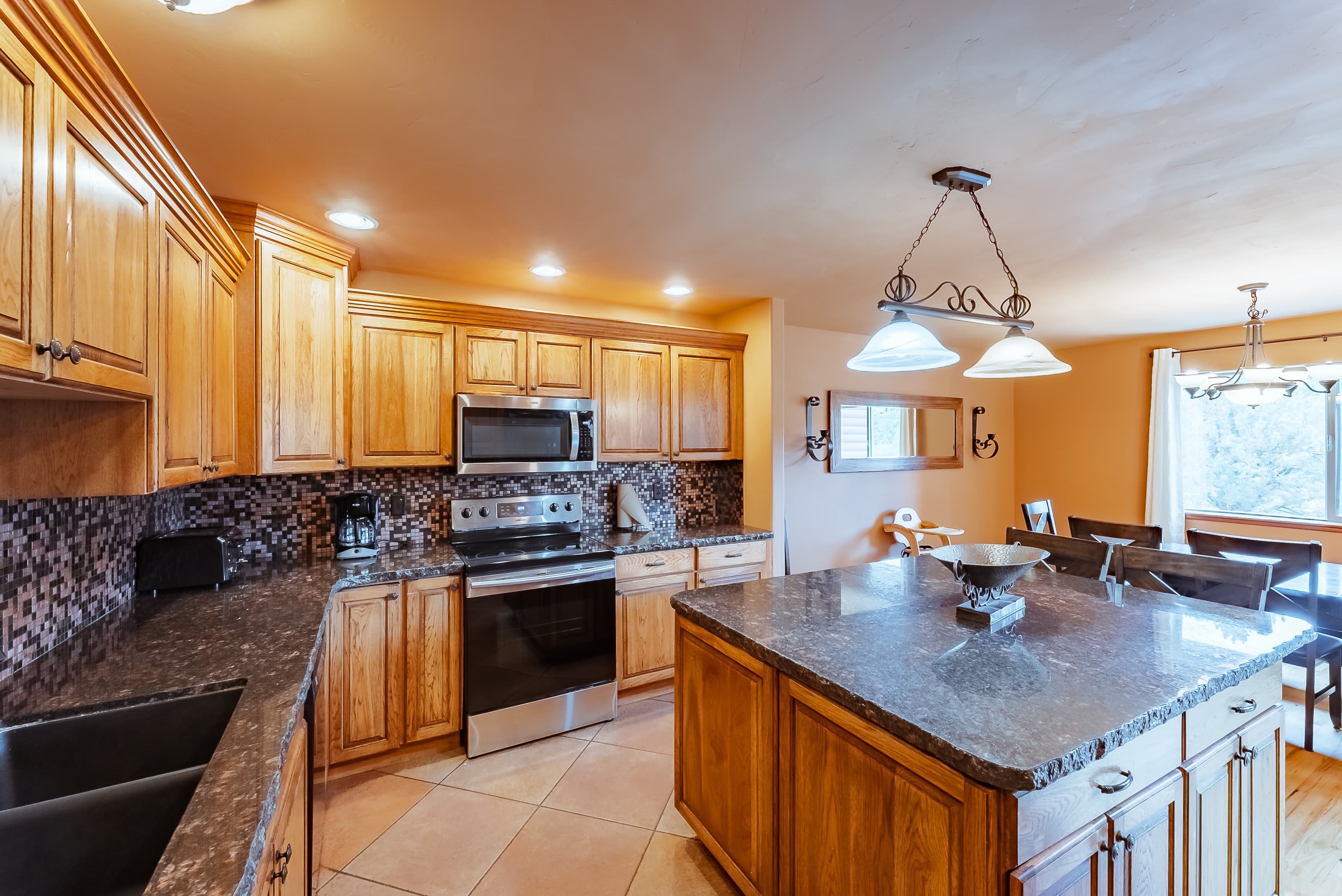 Modern kitchen with wooden cabinets, stainless steel appliances, and a large island.