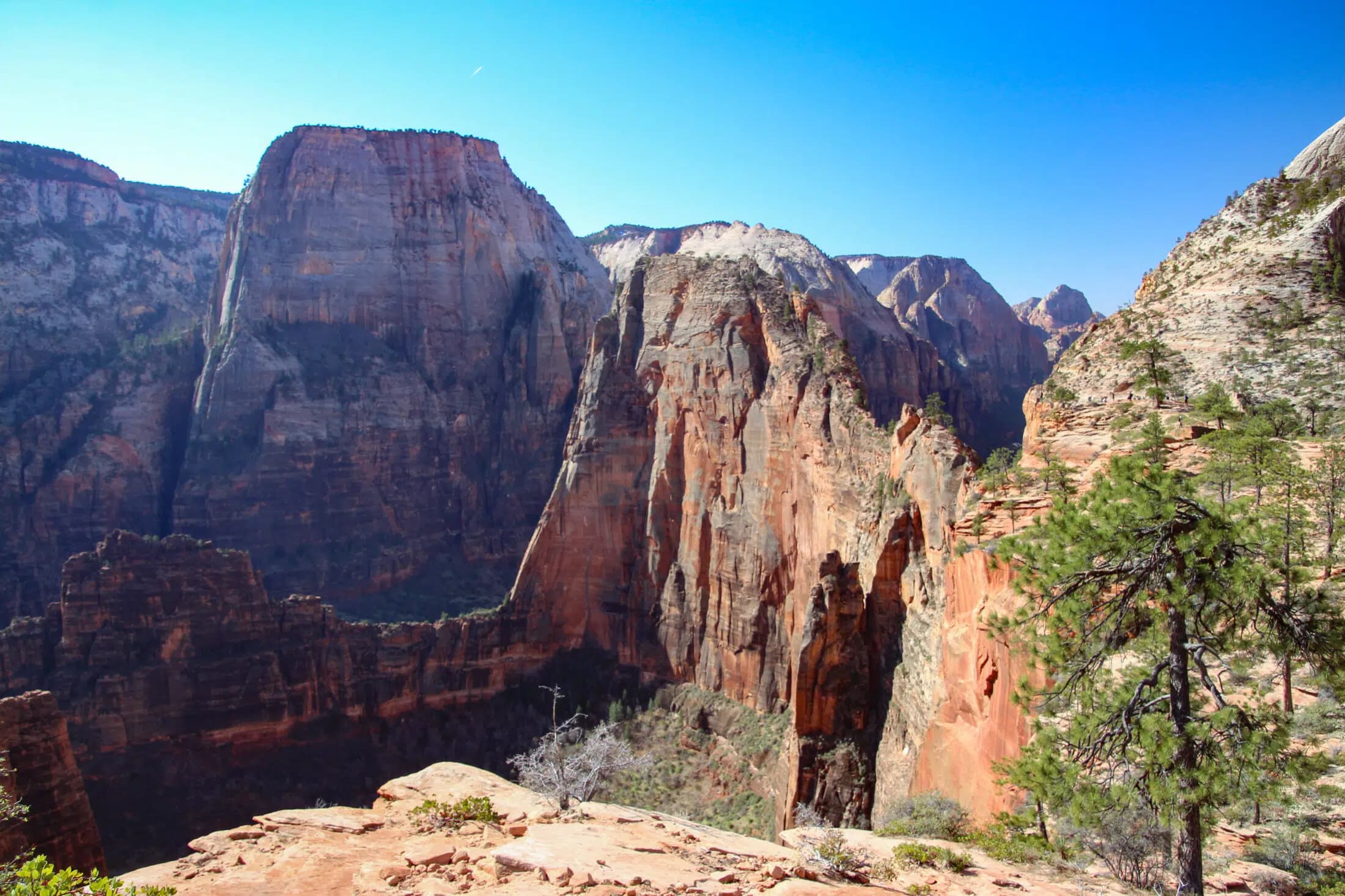 Panoramic view of rugged cliffs and canyons under a clear blue sky.