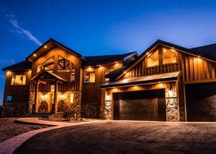 A modern wooden house illuminated at dusk.