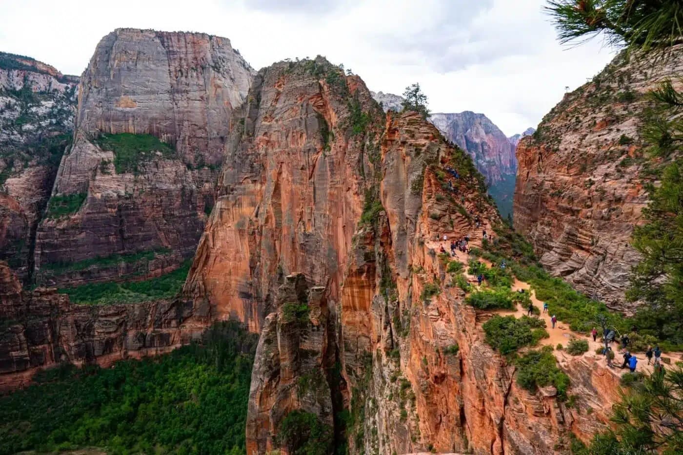 Image of rugged canyon cliffs under a cloudy sky.