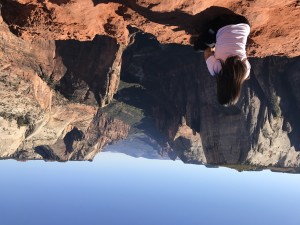 an upside down image of a woman posing for a photo at the top of Angels Landing at Zion national park