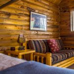 Comfy wood couch in bedroom of log cabin