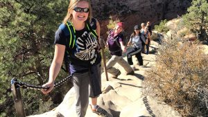 a group of smiling hikers pose for a picture on the trail to Angels Landing in Zion National Park