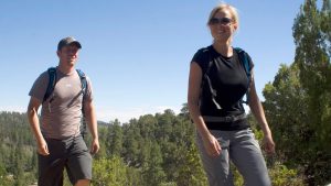 a smiling couple looks on to sights while hiking in the sun near Zion National Park