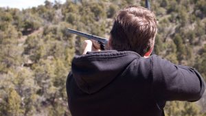 a man shoots a shotgun into the wilderness near Zion Ponderosa Ranch