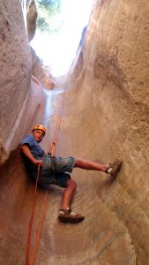 teenage boy repels down a rock wall near zion national park in Utah