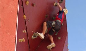 a young man climbs a man made rock wall at zion ponderosa ranch