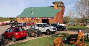 cars and trucks are parked in a lot outside of a barn at Zion ponderosa ranch