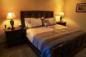 A neatly made queen bed inside of a vacation home at Zion Ponderosa Ranch