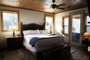 a neatly made double bed in a rustic bedroom inside of a vacation home at Zion Ponderosa Ranch